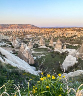 Goreme, Cappadocia 'da güzel bir günbatımında peri bacaları ve kırmızı vadi manzarası 