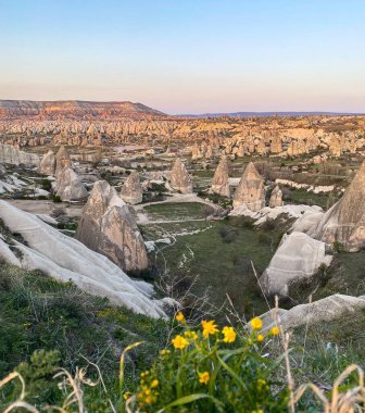 Goreme, Cappadocia 'da güzel bir günbatımında peri bacaları ve kırmızı vadi manzarası 
