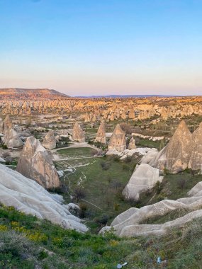 Goreme, Cappadocia 'da güzel bir günbatımında peri bacaları ve kırmızı vadi manzarası 