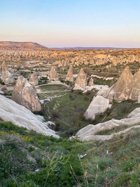 Goreme, Cappadocia 'da güzel bir günbatımında peri bacaları ve kırmızı vadi manzarası 