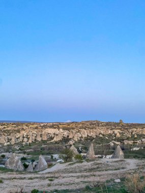 Goreme, Cappadocia 'da güzel bir günbatımında peri bacaları ve kırmızı vadi manzarası 