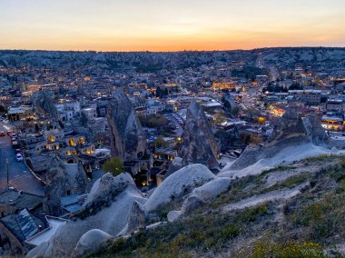 Goreme, Cappadocia 'da güzel bir günbatımında peri bacaları ve kırmızı vadi manzarası 