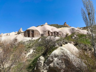 Güvercinler Vadisi ve Uchisar Kalesi manzarası, Goreme, Kapadokya 'da doğal kaya oluşumu ve mağara evleri ile muhteşem bir manzara.