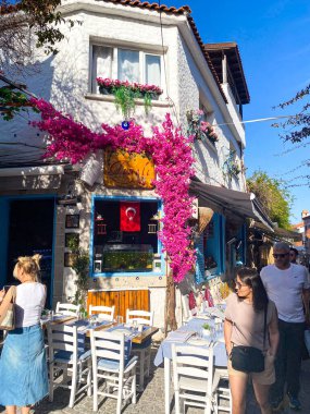 Alacati 'nin küçük, sevimli bir kasabası, kaldırımtaşı sokak aralığı, canlı ve modaya uygun kafeler, restoranlar ve güzel renkli dekorasyonlarla dolu. 