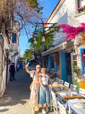 Alacati 'nin küçük, sevimli bir kasabası, kaldırımtaşı sokak aralığı, canlı ve modaya uygun kafeler, restoranlar ve güzel renkli dekorasyonlarla dolu. 