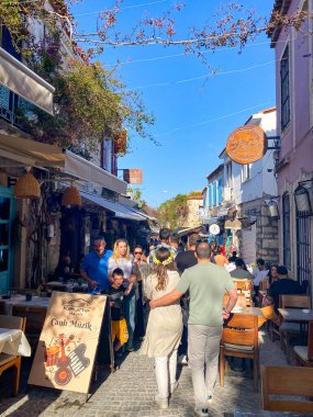 Alacati 'nin küçük, sevimli bir kasabası, kaldırımtaşı sokak aralığı, canlı ve modaya uygun kafeler, restoranlar ve güzel renkli dekorasyonlarla dolu. 