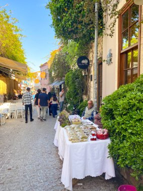 Alacati 'nin küçük, sevimli bir kasabası, kaldırımtaşı sokak aralığı, canlı ve modaya uygun kafeler, restoranlar ve güzel renkli dekorasyonlarla dolu. 