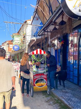 Alacati 'nin küçük, sevimli bir kasabası, kaldırımtaşı sokak aralığı, canlı ve modaya uygun kafeler, restoranlar ve güzel renkli dekorasyonlarla dolu. 