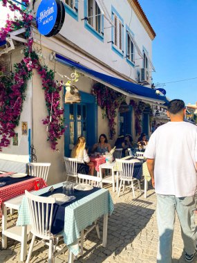 Alacati 'nin küçük, sevimli bir kasabası, kaldırımtaşı sokak aralığı, canlı ve modaya uygun kafeler, restoranlar ve güzel renkli dekorasyonlarla dolu. 