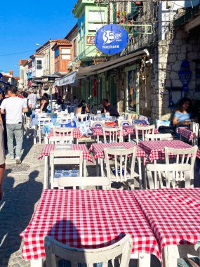 Alacati 'nin küçük, sevimli bir kasabası, kaldırımtaşı sokak aralığı, canlı ve modaya uygun kafeler, restoranlar ve güzel renkli dekorasyonlarla dolu. 