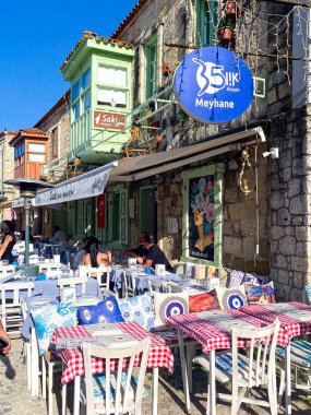 Alacati 'nin küçük, sevimli bir kasabası, kaldırımtaşı sokak aralığı, canlı ve modaya uygun kafeler, restoranlar ve güzel renkli dekorasyonlarla dolu. 