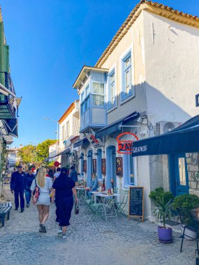 Alacati 'nin küçük, sevimli bir kasabası, kaldırımtaşı sokak aralığı, canlı ve modaya uygun kafeler, restoranlar ve güzel renkli dekorasyonlarla dolu. 