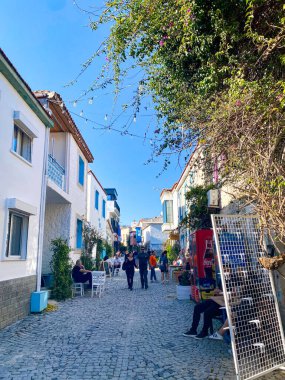Alacati 'nin küçük, sevimli bir kasabası, kaldırımtaşı sokak aralığı, canlı ve modaya uygun kafeler, restoranlar ve güzel renkli dekorasyonlarla dolu. 