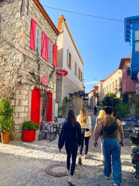 Alacati 'nin küçük, sevimli bir kasabası, kaldırımtaşı sokak aralığı, canlı ve modaya uygun kafeler, restoranlar ve güzel renkli dekorasyonlarla dolu. 