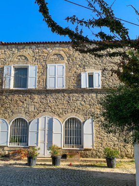 Alacati 'nin küçük, sevimli bir kasabası, kaldırımtaşı sokak aralığı, canlı ve modaya uygun kafeler, restoranlar ve güzel renkli dekorasyonlarla dolu. 