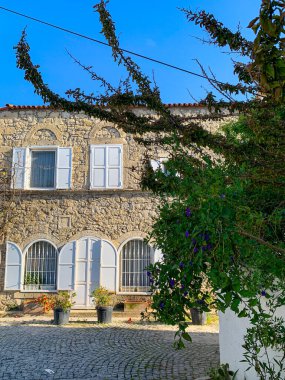 Alacati 'nin küçük, sevimli bir kasabası, kaldırımtaşı sokak aralığı, canlı ve modaya uygun kafeler, restoranlar ve güzel renkli dekorasyonlarla dolu. 