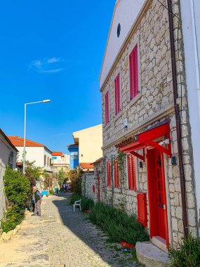 Alacati 'nin küçük, sevimli bir kasabası, kaldırımtaşı sokak aralığı, canlı ve modaya uygun kafeler, restoranlar ve güzel renkli dekorasyonlarla dolu. 
