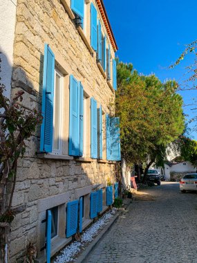 Alacati 'nin küçük, sevimli bir kasabası, kaldırımtaşı sokak aralığı, canlı ve modaya uygun kafeler, restoranlar ve güzel renkli dekorasyonlarla dolu. 