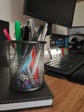 Kalemler, mekanik kalemler, kalemler, günlükler, bilgisayar gibi iş materyalleri içeren masa