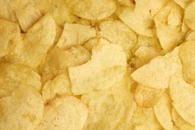 Altın, çıtır çıtır patates cipslerinin detaylı yakın plan görüntüsü atıştırmak için birebir.