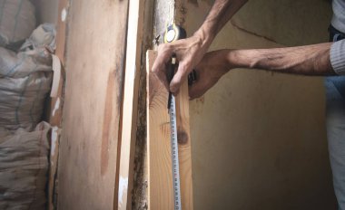 Cetvelli marangoz ahşap kalas ölçüyor..