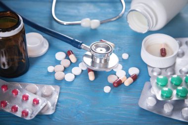 Steteskop ve mavi arka planda farklı haplar..