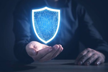 İş adamı kalkanı tutuyor ve tablet kullanıyor. Koruma