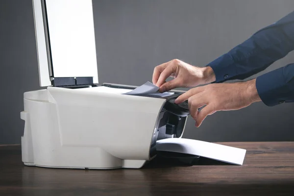 Man copying and scanning documents in office.