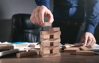  Tahta blokları istifleyen bir adam. İş için. Plan yap. Strateji