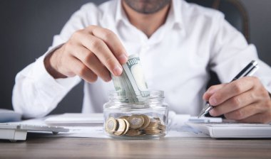 İş adamı cam bankaya para yatırıyor. Para biriktiriliyor