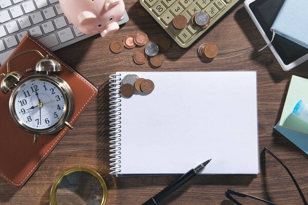 Empty notepad, coins, pen and business objects.
