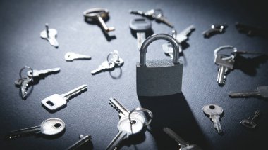 Siyah arkaplanda asma kilit ve anahtarlar.