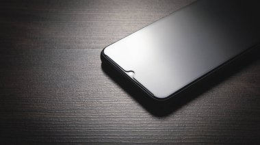 Ahşap arka planda yeni akıllı telefon.