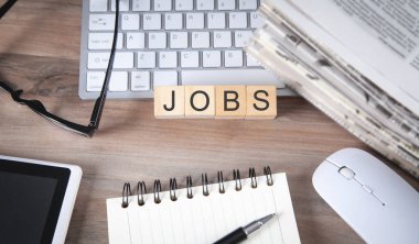 Gazete ve bilgisayar klavyeli tahta küplerdeki görevler.