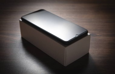 Ahşap arka planda yeni akıllı telefon.