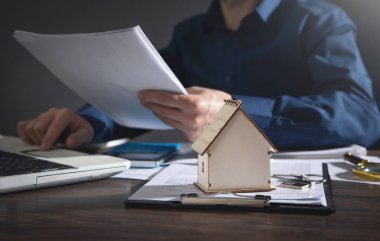 Emlakçı ev kredisi sigortası için belge tutuyor.
