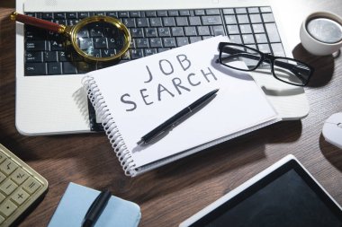 Not defterindeki görev arama metni bir büyüteç, kalem ve diğer nesneler ile.