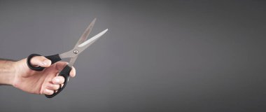 Siyah bir makas tutan erkek el..