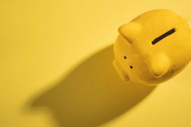 Sarı arka planda sarı domuz kumbarası.