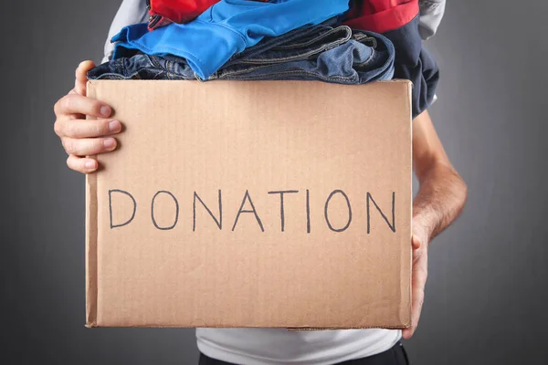 Man holding Donation box with a clothes.