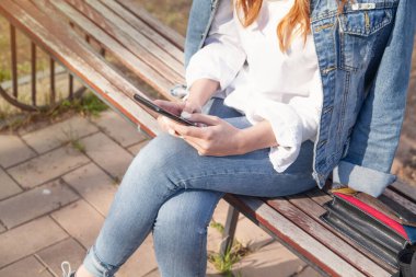 Dışarıda cep telefonu kullanan genç bir kadın..