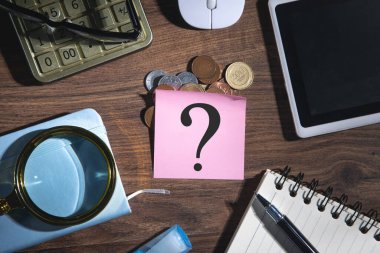 Bir iş nesnesiyle yapışkan nottaki soru işareti.