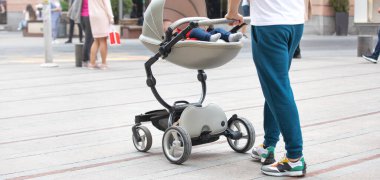 Babası bebek arabasıyla şehirde yürüyor..