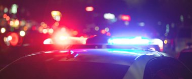 Kırmızı ve mavi ışık teşhircisi. Şehirde gece vakti polis arabası.