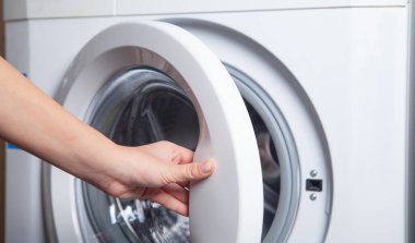 El çamaşır makinesinin kapısını açtı..