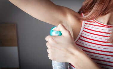 Koltuk altına deodorant süren genç bir kadın..