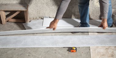 Plastik panel tutan bir işçi. Tavanı yeniliyorum.