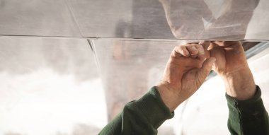 İnşaat işçisi asılmış tavanı monte ediyor.