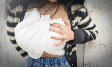 Göğsüne dokunan genç bir kadın. Göğüs ağrısı.