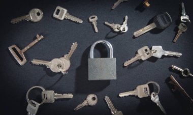 Siyah arkaplanda asma kilit ve anahtarlar.